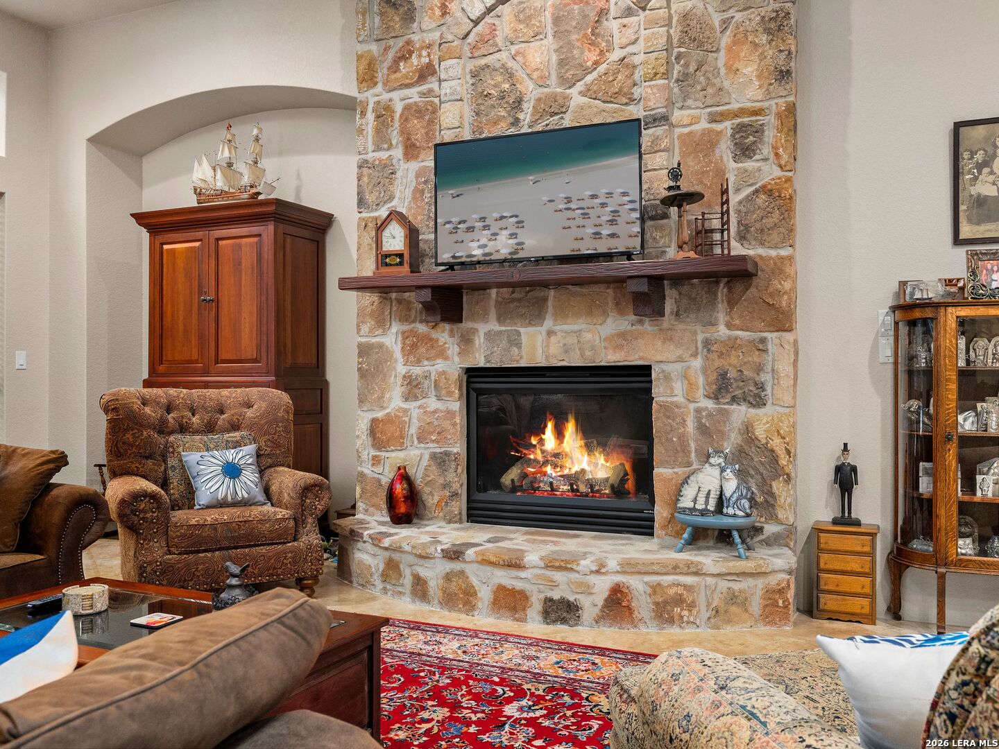 19819 Wild Hollow Garden Ridge, TX 78266 - Photo 16 of 68 a living room with furniture a flat screen tv and a fireplace