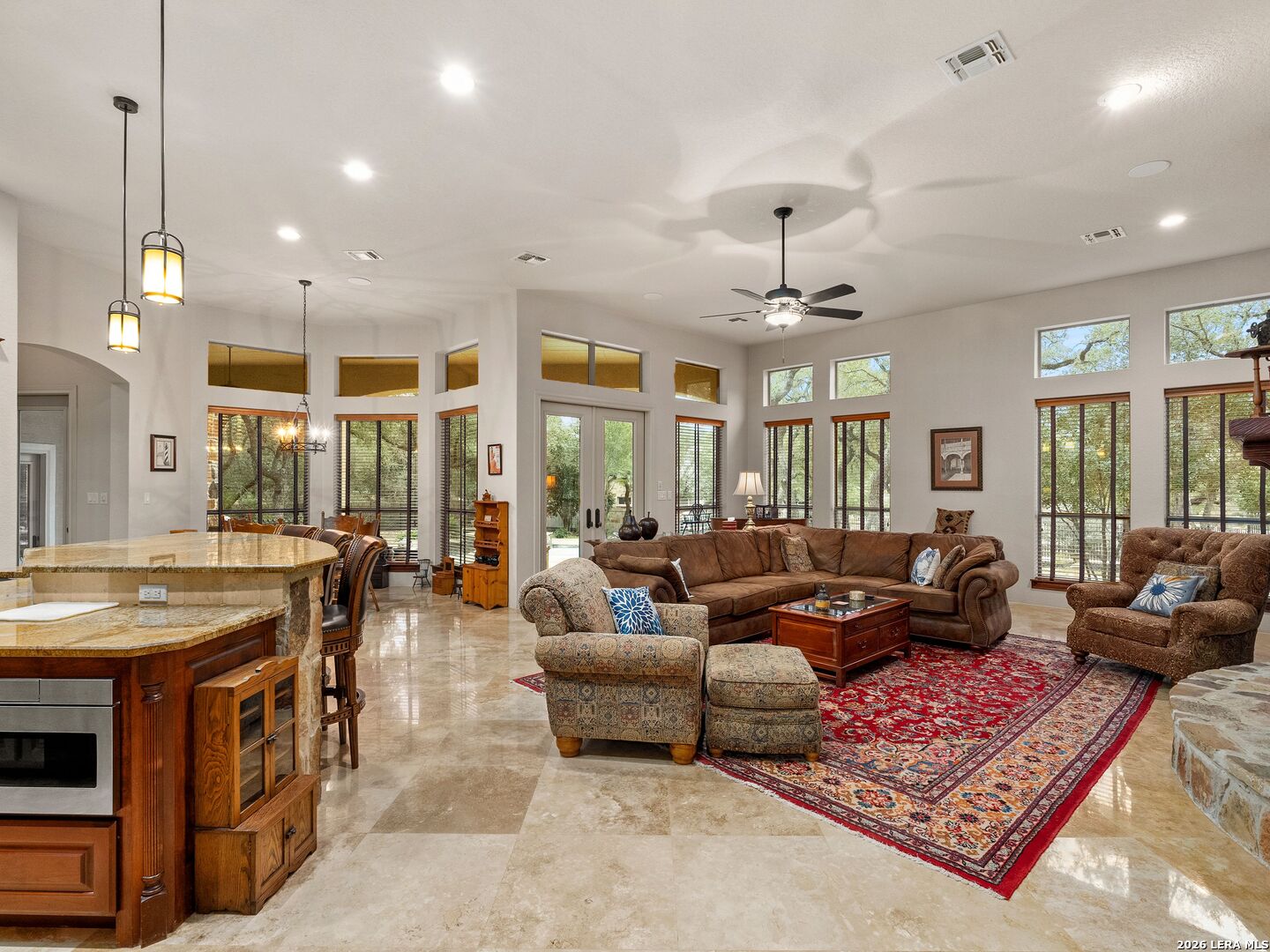 19819 Wild Hollow Garden Ridge, TX 78266 - Photo 18 of 68 a living room with furniture a chandelier and a fireplace