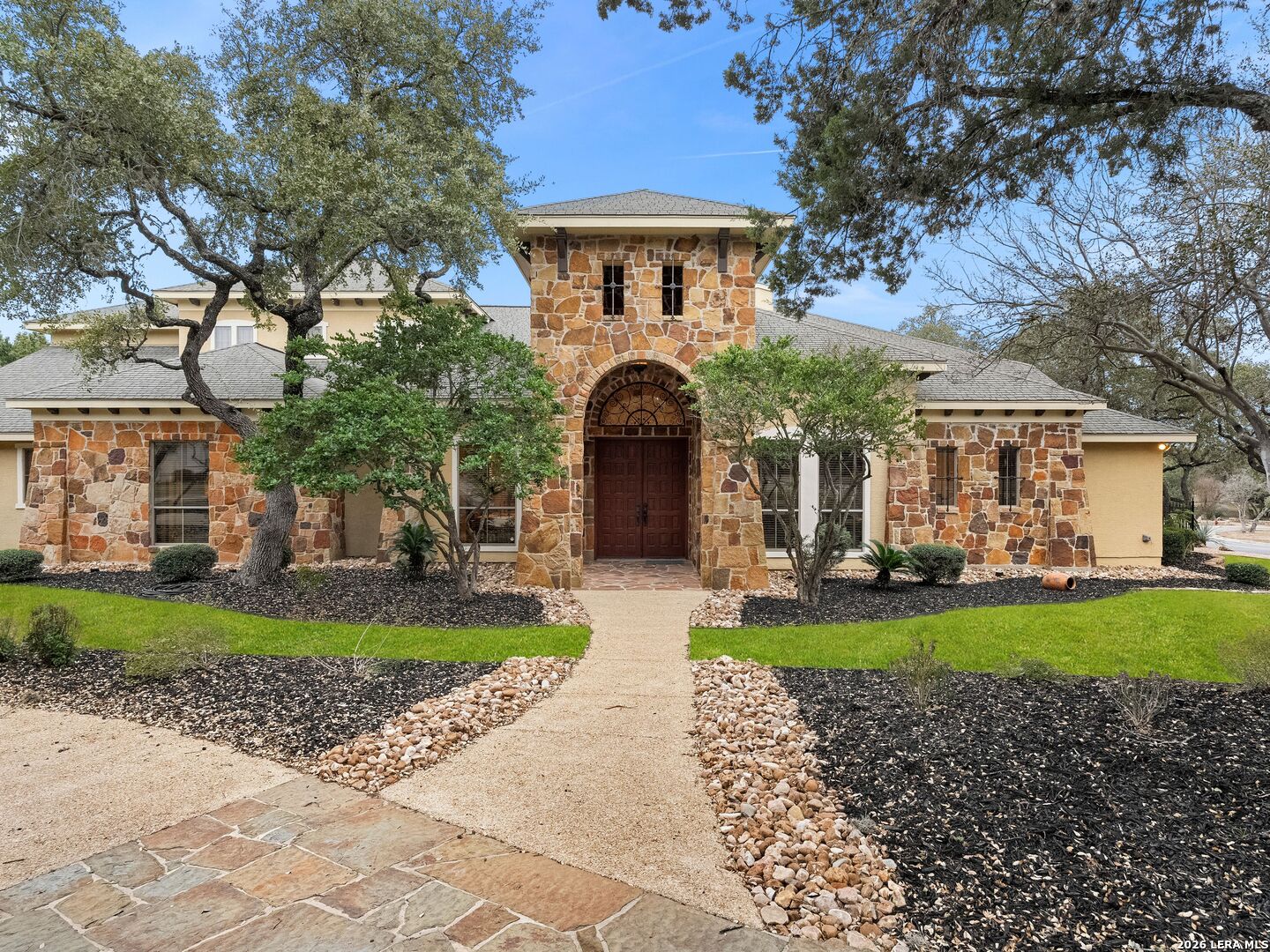 19819 Wild Hollow Garden Ridge, TX 78266 - Photo 10 of 68 a front view of a house with a garden and trees