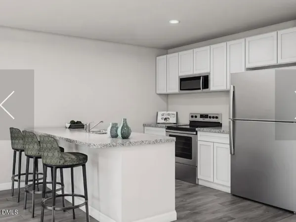 a kitchen with stainless steel appliances granite countertop a stove a sink dishwasher a refrigerator white cabinets and a refrigerator