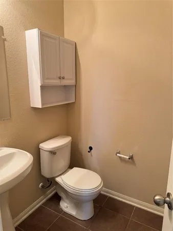 a white toilet sitting next to a bathroom sink