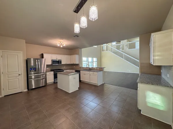 a kitchen with refrigerator and cabinets