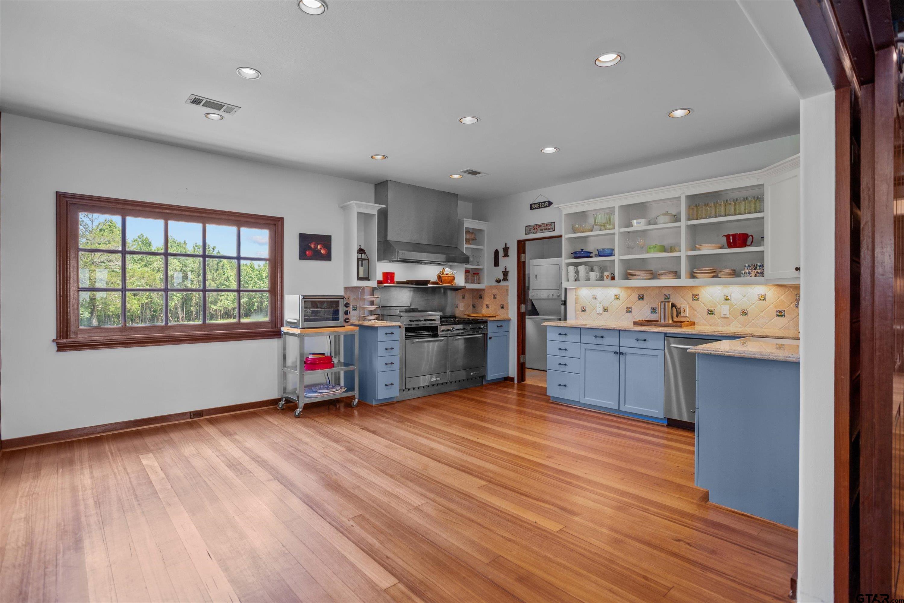 656 Vineyard View Ranch Grapeland, TX 75844 - Photo 13 of 31 a kitchen with stainless steel appliances wooden floors and wooden cabinets