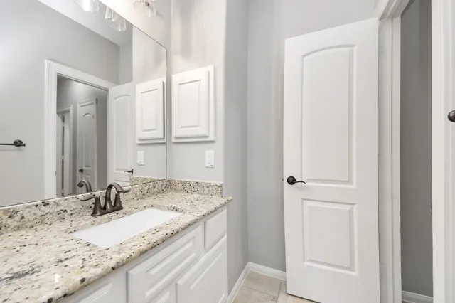 a bathroom with a granite countertop sink and a mirror