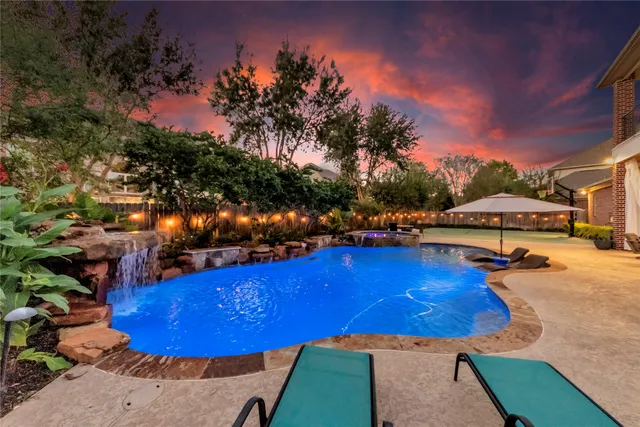 a view of a swimming pool with outdoor seating and plants