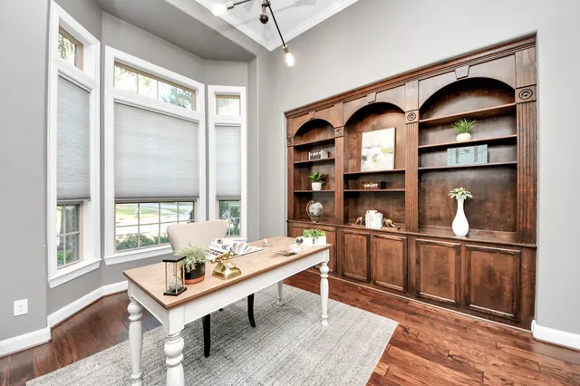 a living room with stainless steel appliances furniture a rug and a large window