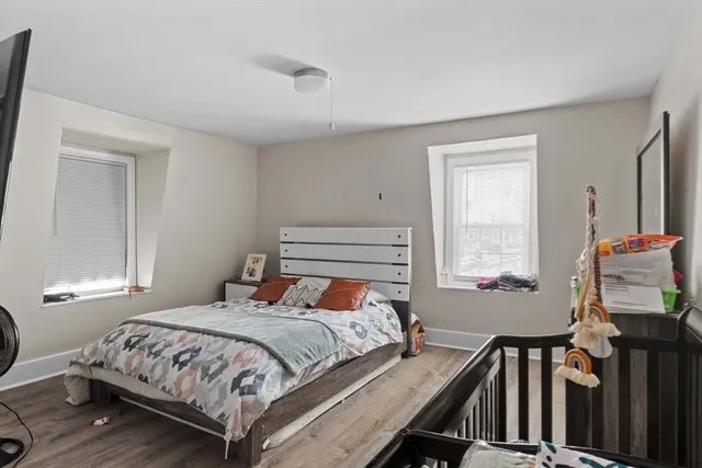 a bedroom with a bed and wooden floor