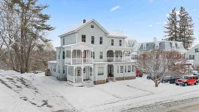 a view of a white house with a yard covered in snow