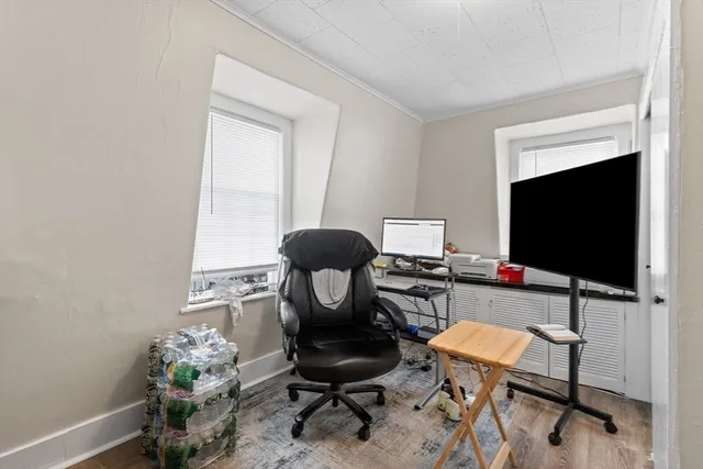 a work room with furniture and a flat screen tv
