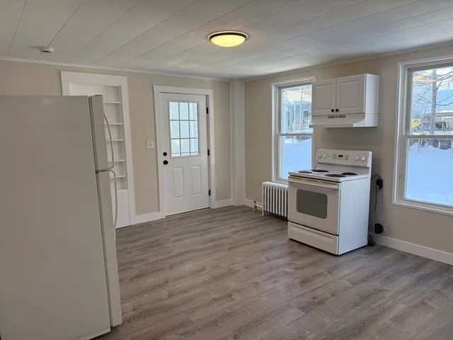 a view of kitchen with stainless steel appliances granite countertop a stove and a refrigerator