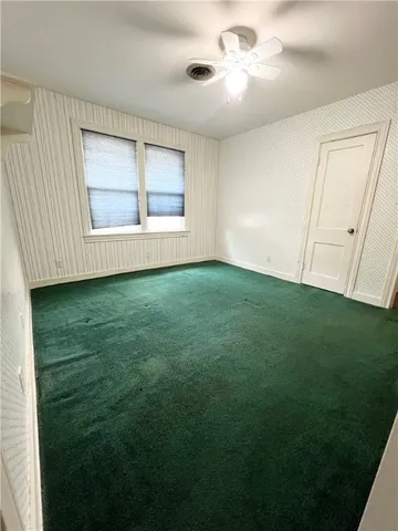 a view of an empty room with window and cabinet