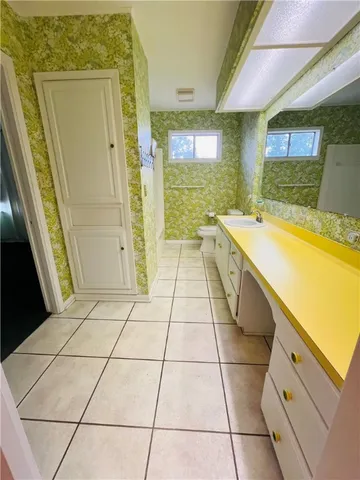 a bathroom with a sink a toilet a mirror and shower