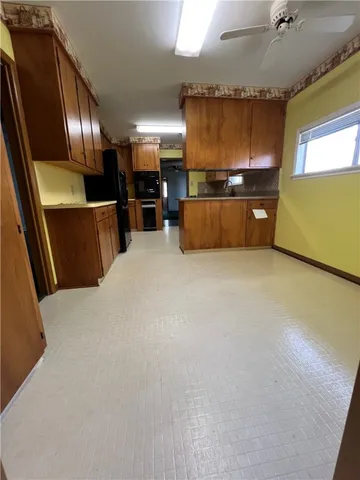 a view of an empty room with a kitchen