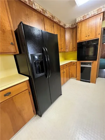 a kitchen with stainless steel appliances a refrigerator and a wooden fence