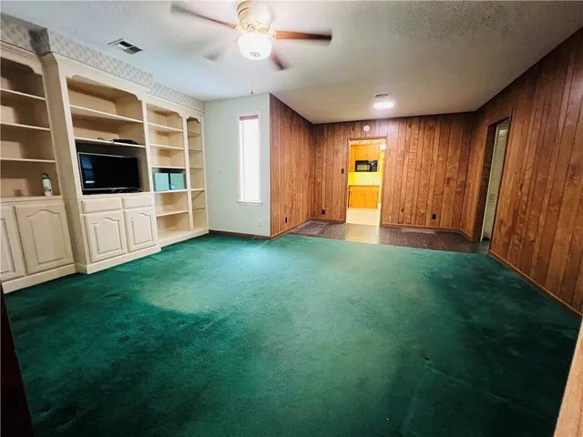 a view of an empty room with window and furniture
