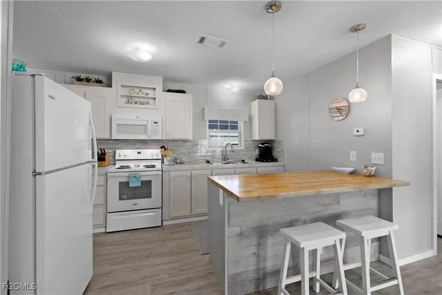 a kitchen with white cabinets and white appliances