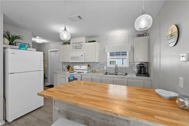 a kitchen with kitchen island a stove a refrigerator and a sink