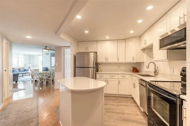 a kitchen with stainless steel appliances a refrigerator sink and microwave