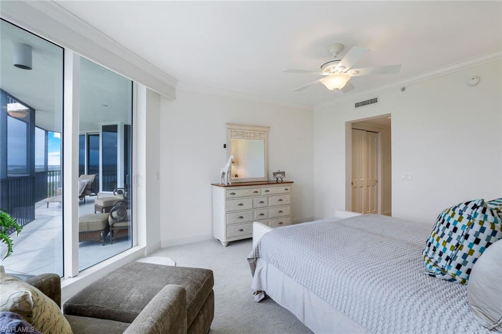 1060 Borghese Lane, Unit 1005 Naples, FL 34114 - Photo 12 of 38 a bedroom with a bed and a chandelier