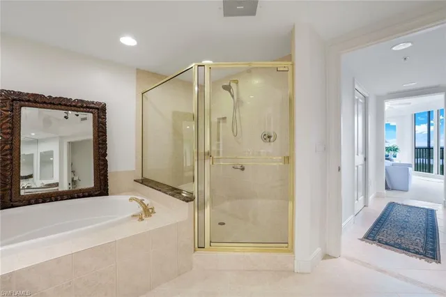 a bathroom with a bathtub a shower a sink and a mirror
