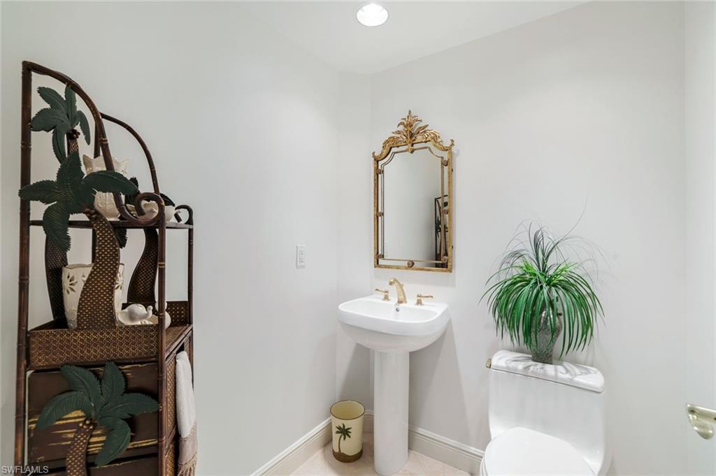 1060 Borghese Lane, Unit 1005 Naples, FL 34114 - Photo 20 of 38 a bathroom with a sink toilet and mirror