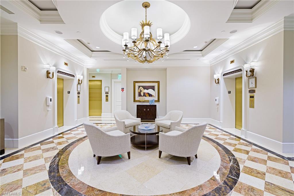 1060 Borghese Lane, Unit 1005 Naples, FL 34114 - Photo 24 of 38 a living room with fireplace furniture and a chandelier