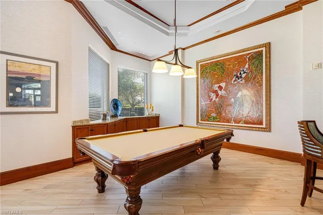 a room with pool table and wooden floor