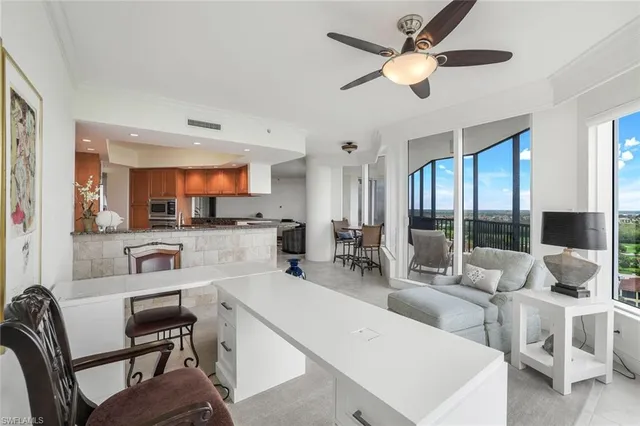 a living room with furniture a flat screen tv and a large window
