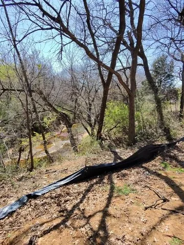 a view of a yard with wooden fence