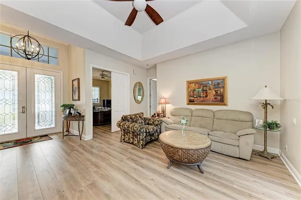 a view of a dining room with furniture a chandelier and wooden floor