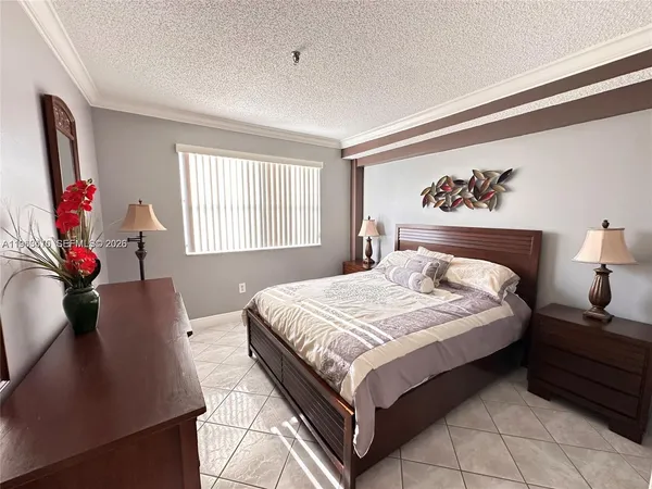 a bedroom with bed and a painting on the wall