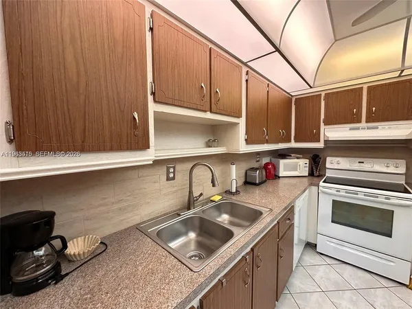 a kitchen with a sink a stove and cabinets