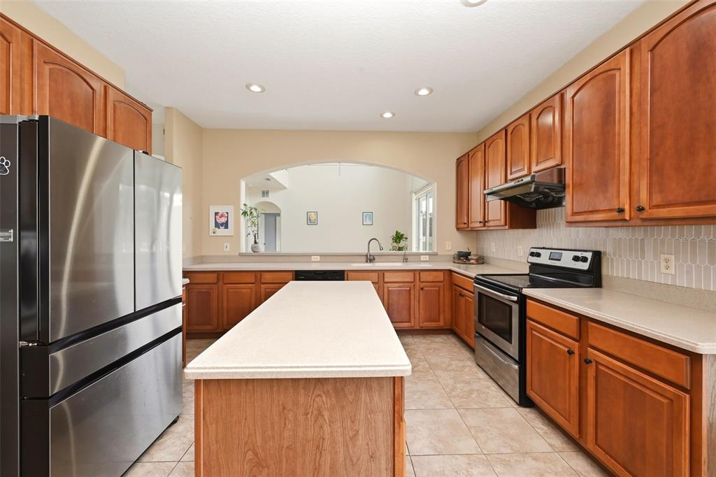 936 Kingsridge Circle Gotha, FL 34734 - Photo 18 of 50 a kitchen with stainless steel appliances granite countertop a refrigerator sink stove microwave and cabinets