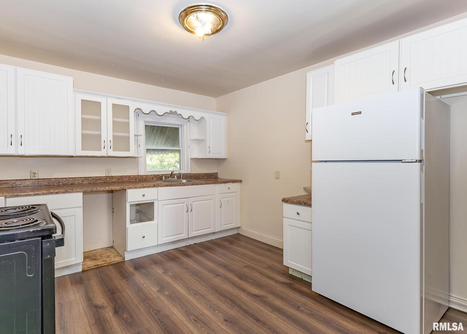 633 7th Avenue South Clinton, IA 52732 - Photo 14 of 19 a kitchen with a refrigerator stove and white cabinets