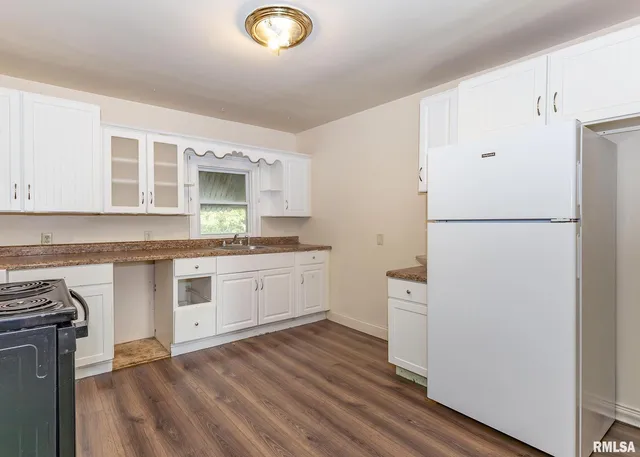 a kitchen with a refrigerator stove and white cabinets