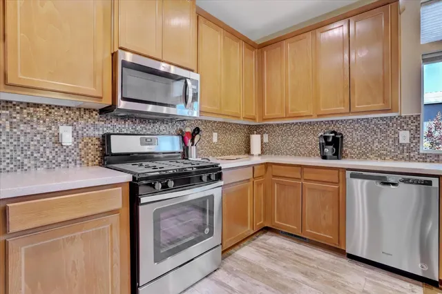 a kitchen with stainless steel appliances a stove a sink and a microwave
