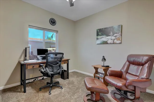 a view of a workspace with furniture and a window