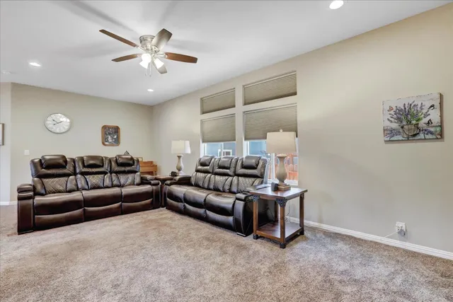 a living room with furniture and a ceiling fan