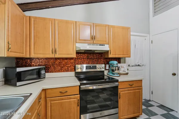 a kitchen with stainless steel appliances sink cabinets and window