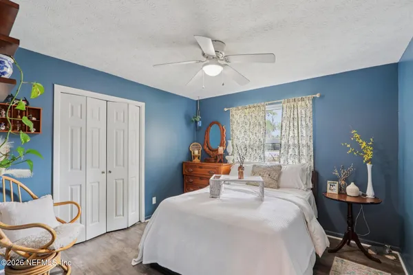 a bedroom with furniture and a chandelier fan