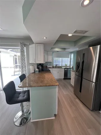 a kitchen with kitchen island granite countertop a stove a sink and a refrigerator