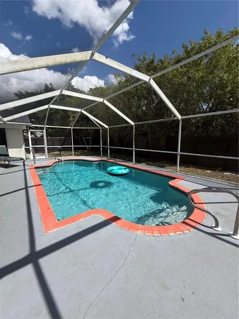 a view of a backyard with table and chairs under an umbrella