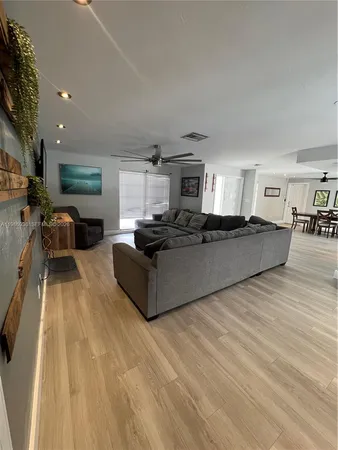 a living room with furniture and a wooden floor