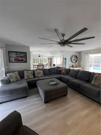 a living room with furniture a ceiling fan and a rug