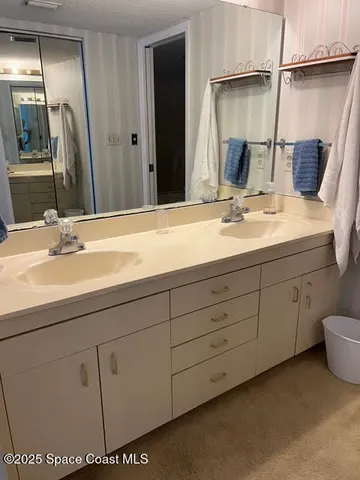 a spacious bathroom with a double vanity sink and a mirror