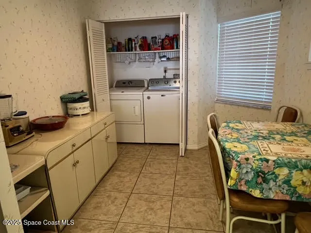 a utility room with dryer washer and empty racks