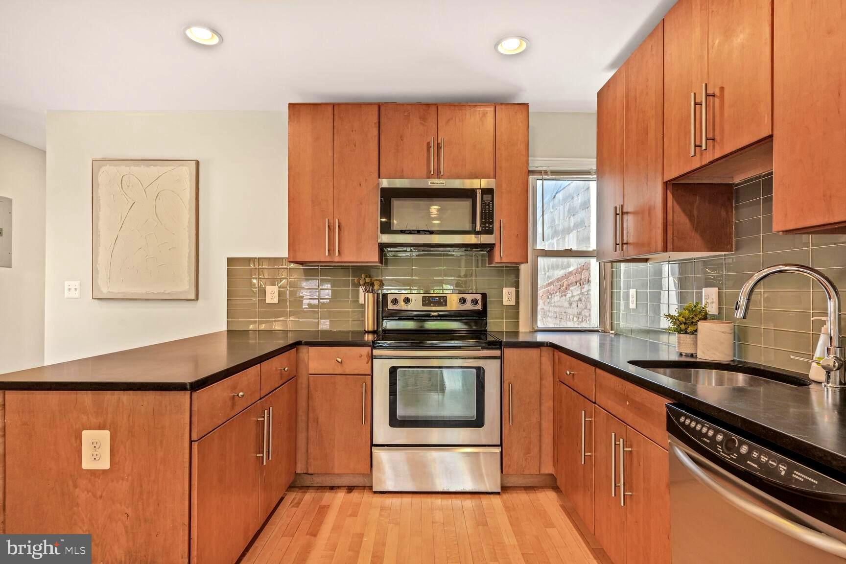 2515 17th Street Northwest, Unit 5 Washington, DC 20009 - Photo 4 of 14 a kitchen with stainless steel appliances granite countertop a stove a sink dishwasher and a microwave oven with cabinets