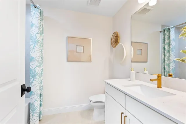 a bathroom with a granite countertop sink a toilet and a mirror