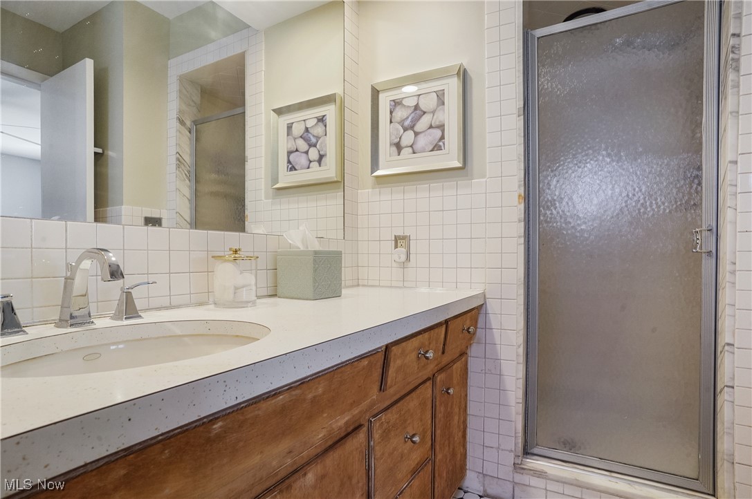 2441 Stockbridge Road Akron, OH 44313 - Photo 29 of 43 Bathroom with vanity, tile walls, and a shower with shower door