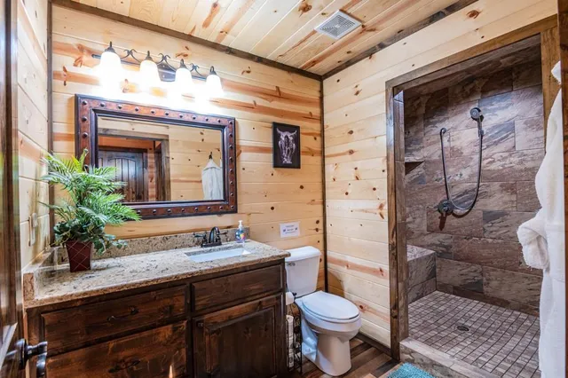 a bathroom with a granite countertop sink toilet mirror and shower